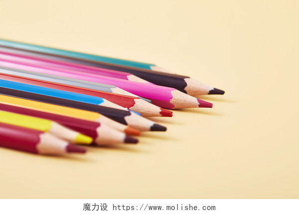 开学季一堆并排彩色铅笔笔头笔尖在纯色背景纸上的场景配图创意图